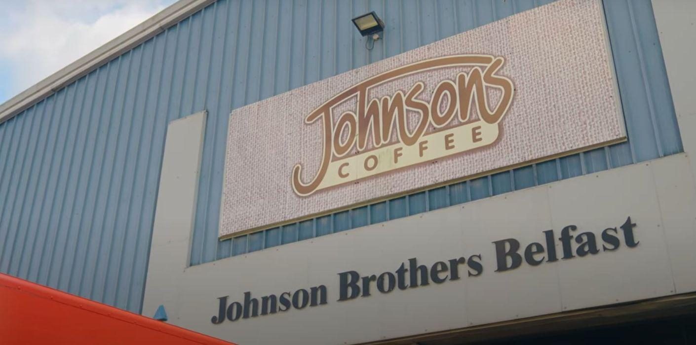Factory close up shot with a sign that reads 'Johnson's coffee@ followed by a sign below that reads 'Johnson Brothers Belfast'