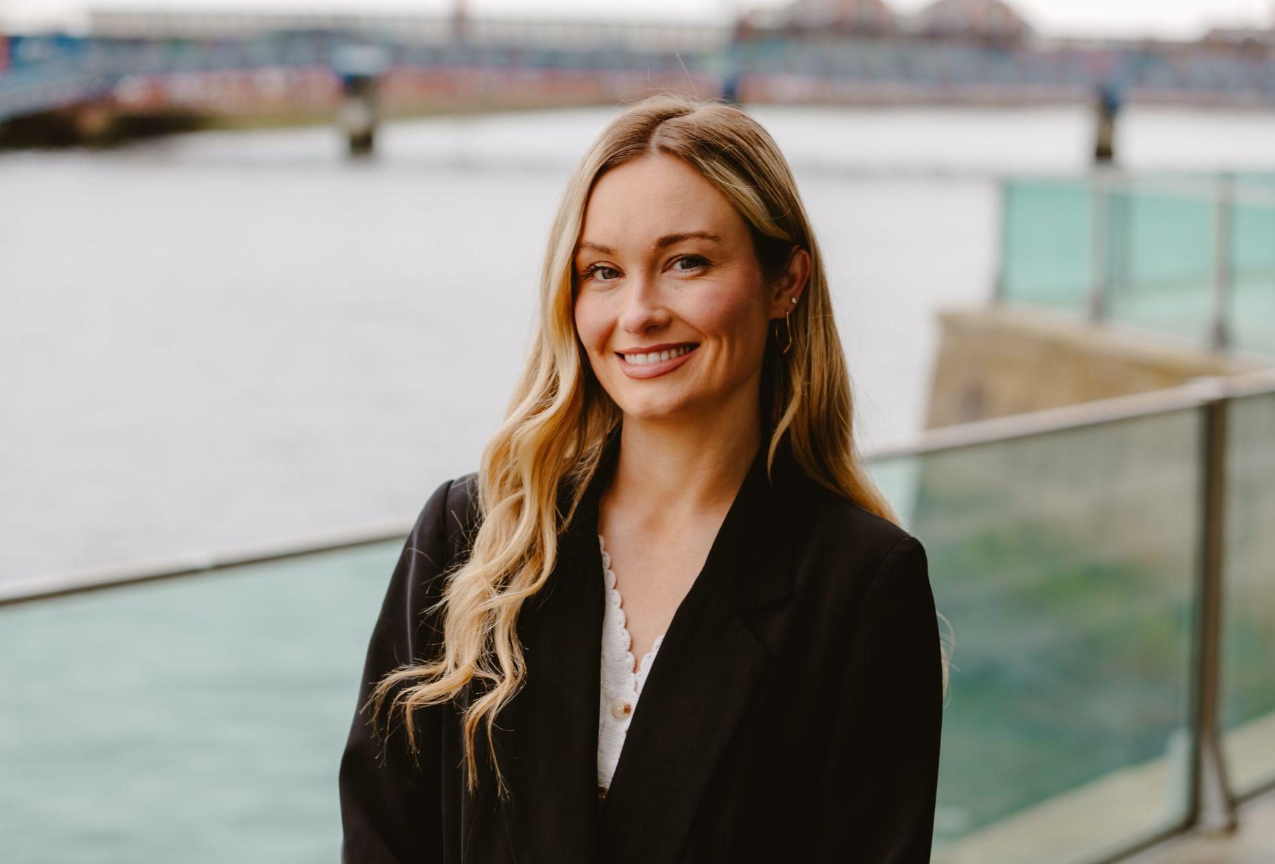 Woman smiling for a headshot outside the ICC Belfast venue along the waterfront