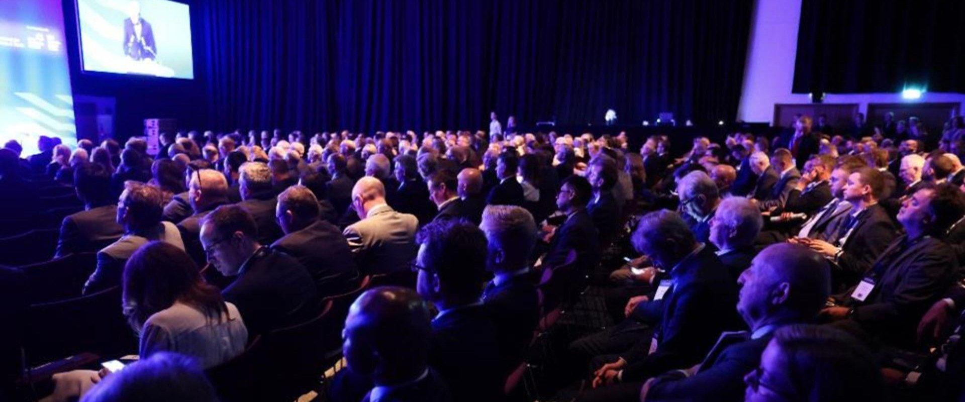 Hall 1 filled with seated delegates for the 2023 Investment conference, all facing the main stage.