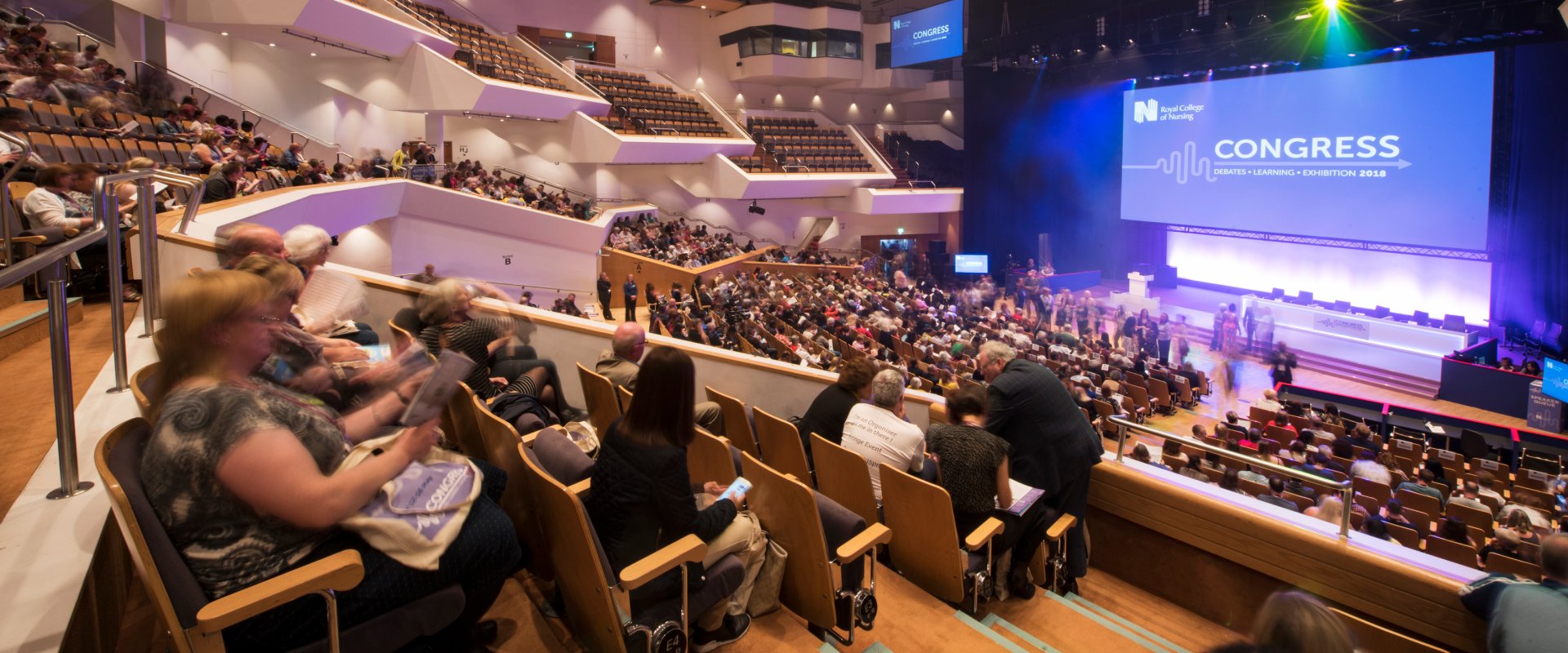 2,000 seat auditorium filled with people facing stage with large screen