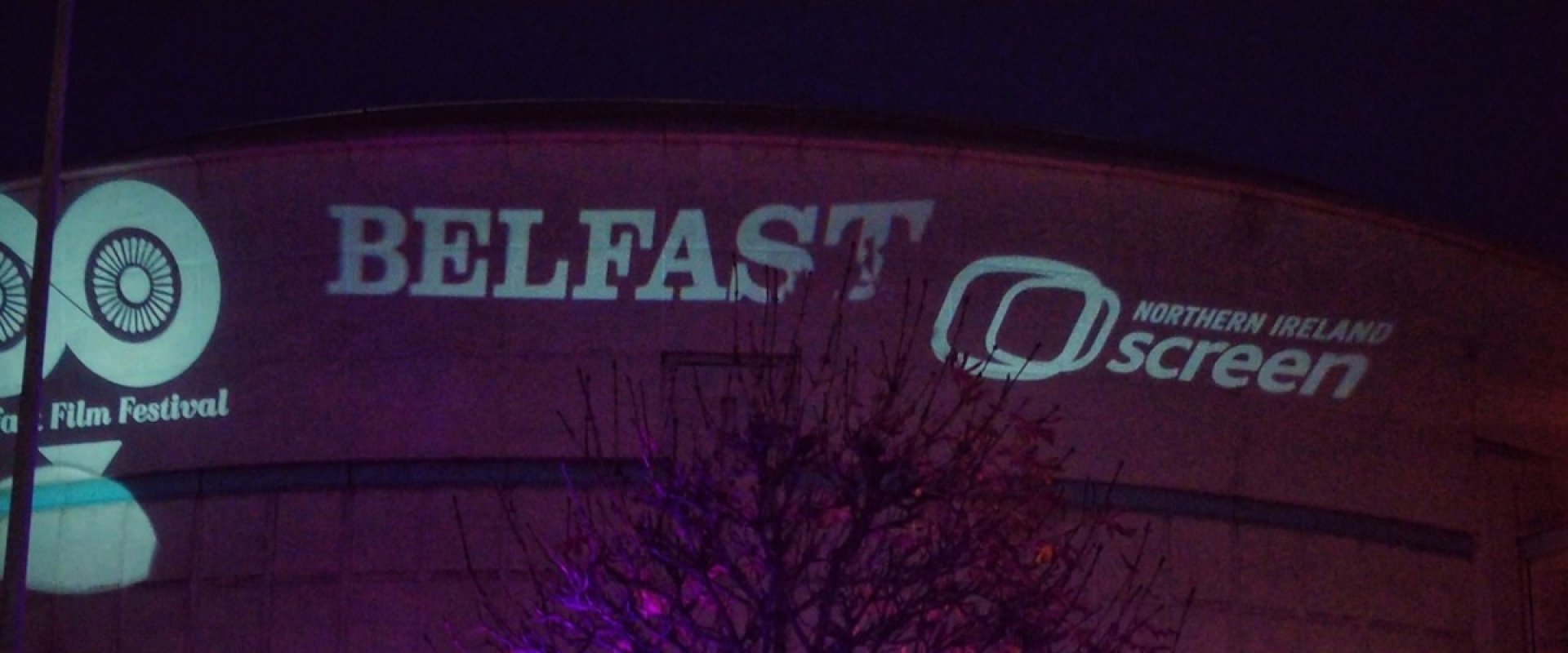 Marquee outside the cityside of ICC Belfast, lit up in pink with delegates gathered.