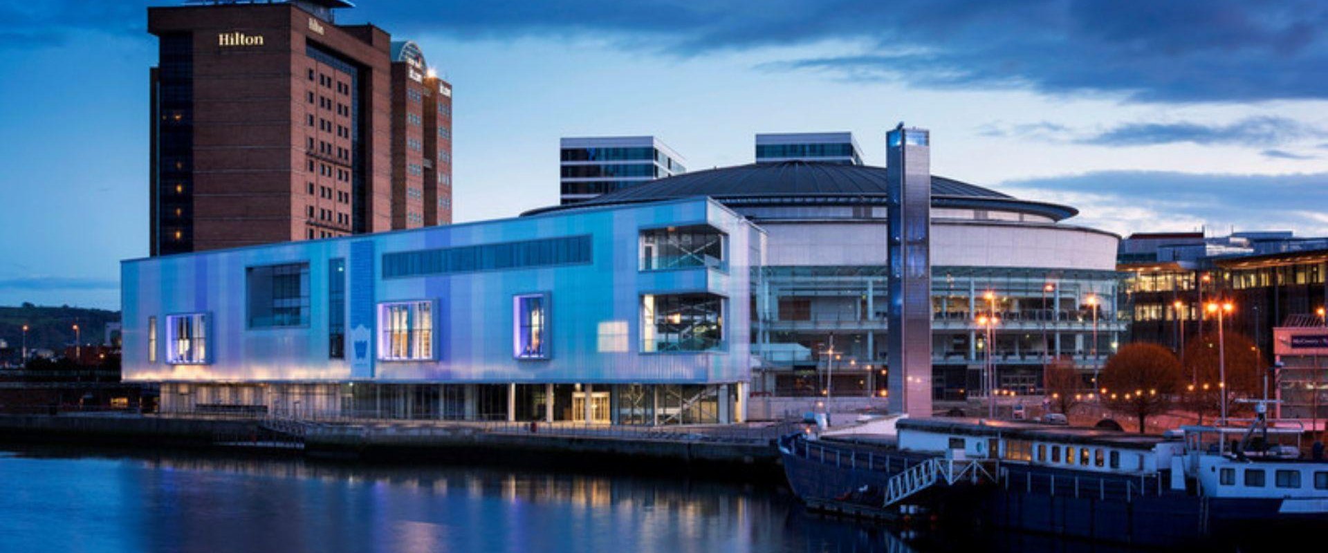 This image shows the exterior of the riverside part of ICC Belfast at dusk.