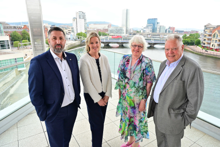 Image of two men and two women smiling on balcony for press shot
