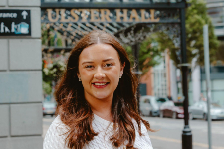Image of girl smiling with Ulster Hall signage in the background