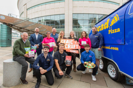 Group of people with food items smile for press shot outside ICC Belfast