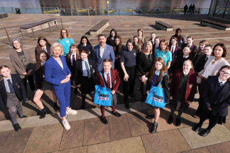 Group of students and professionals stand outside ICC Belfast for press shot in the sun