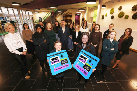 Group of students alongside industry professionals smile for Empower Girls press shot at ICC Belfast