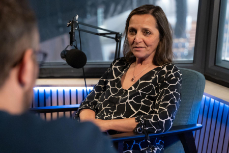 Woman smiles as she speaks with interviewer in studio
