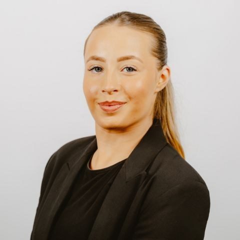 Woman smiling for a photo against a white background
