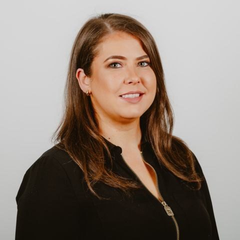 Woman smiling for a headshot against a white background