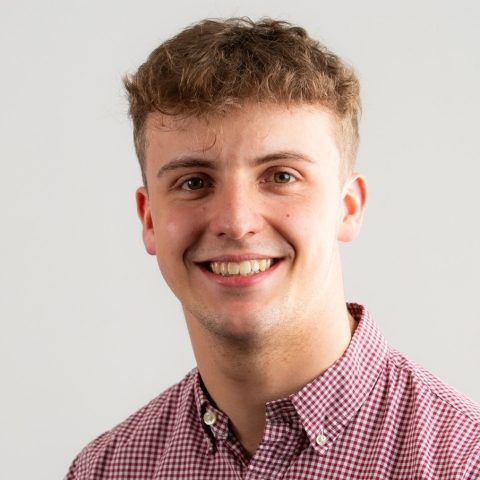 Man smiles for headshot against white background