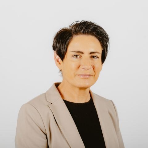 Woman smiling for a photo in front of a white background