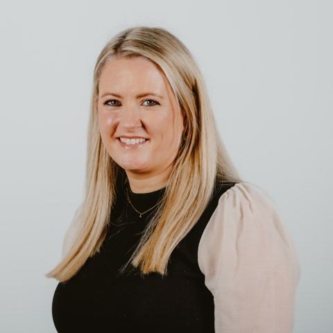 Woman smiling for headshot against a white background