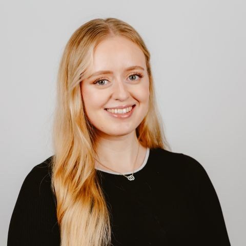 Woman smiling for headshot against a white background