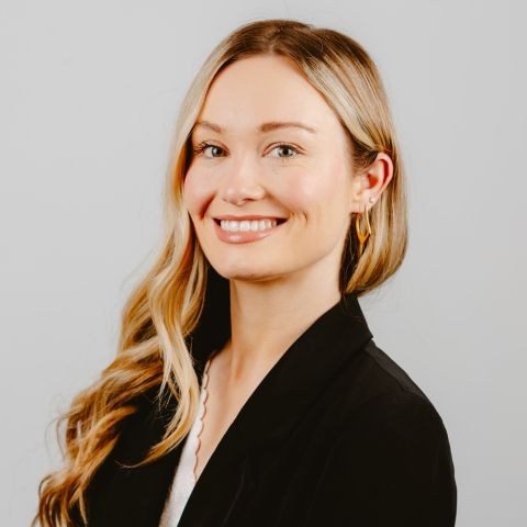 Woman smiling for a headshot against white background