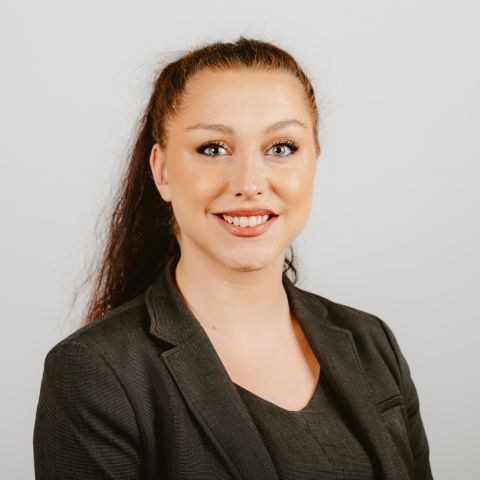 Woman smiling for headshot against a white background