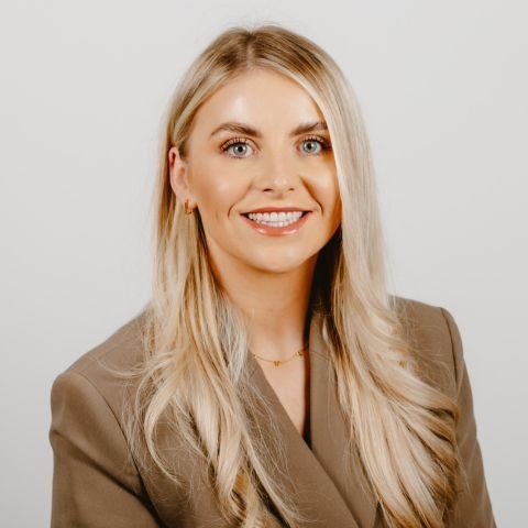 Woman smiling for a photo against a white background