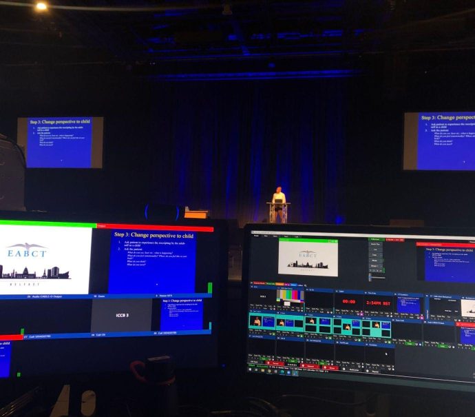 Image displays the stage set for the EABCT Conference from the technical point of view, with different monitors.