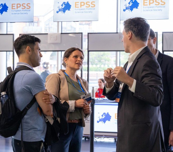 Image of one woman and three men in conversation at a conference
