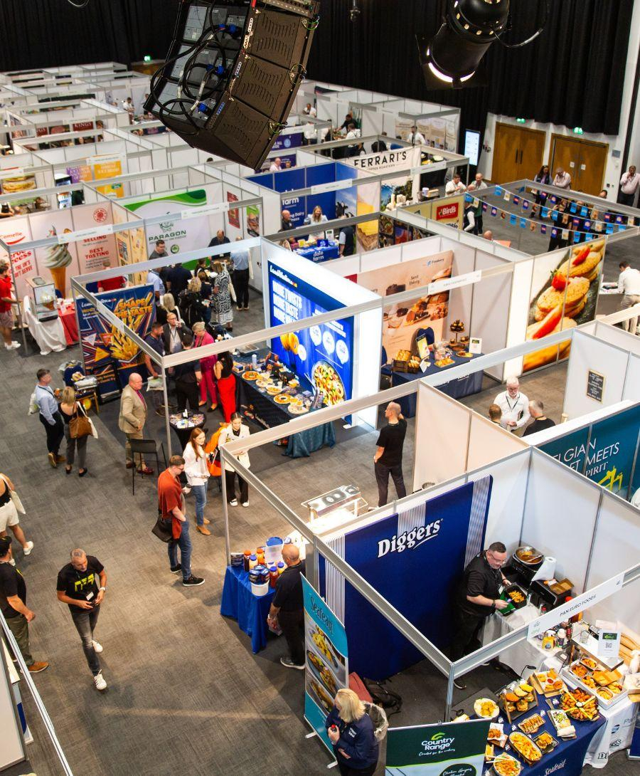 Birdseye view captured of a food exhibition set up filled with colour and people exploring the stalls