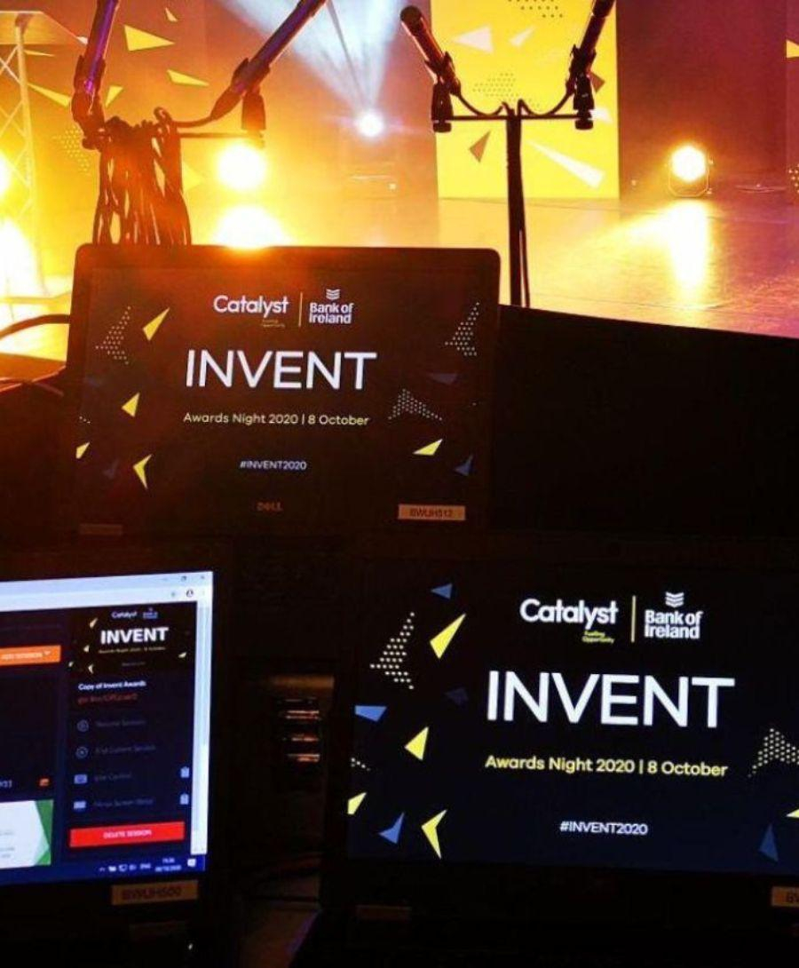 Event production set up for the Invent 2020 awards in ICC Belfast's Hybrid Studio. Multiple screens are visible with the stage in the background lit with yellow lights.