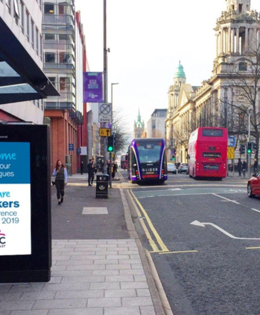 An outdoor advertisement at a bus stop on May St in Belfast city centre promoting We are Lookers conference Belfast 2019.