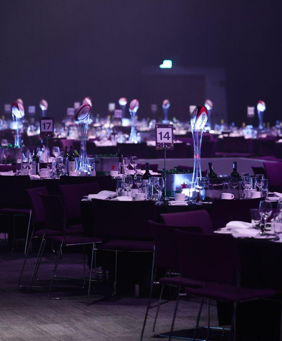 ICC Belfast's Hall 1 set up for the Ulster Rugby Gala Dinner in banquet style. The tables are all numbered and have a rugby ball as a centrepiece.