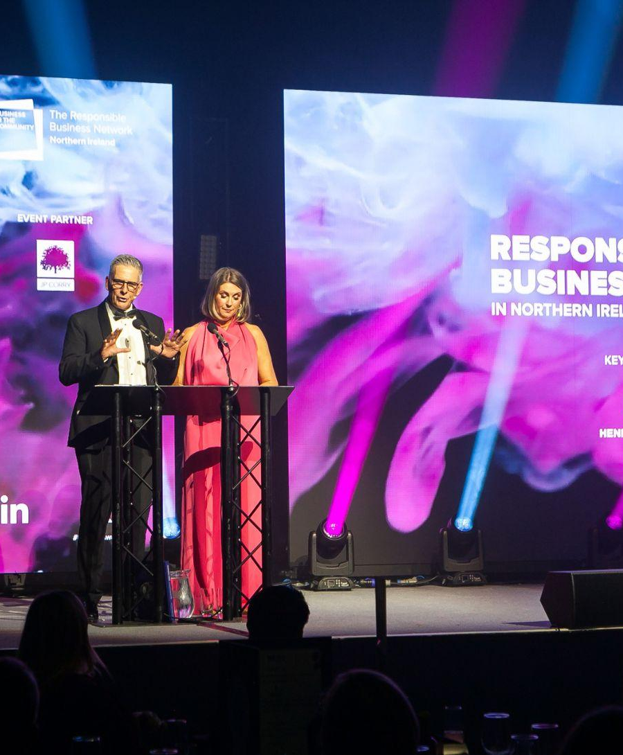 Presenters Mark Simpson and Sarah Travers on Hall 1 stage for the Business In the Community (BITC) NI Responsible Business Awards 2024