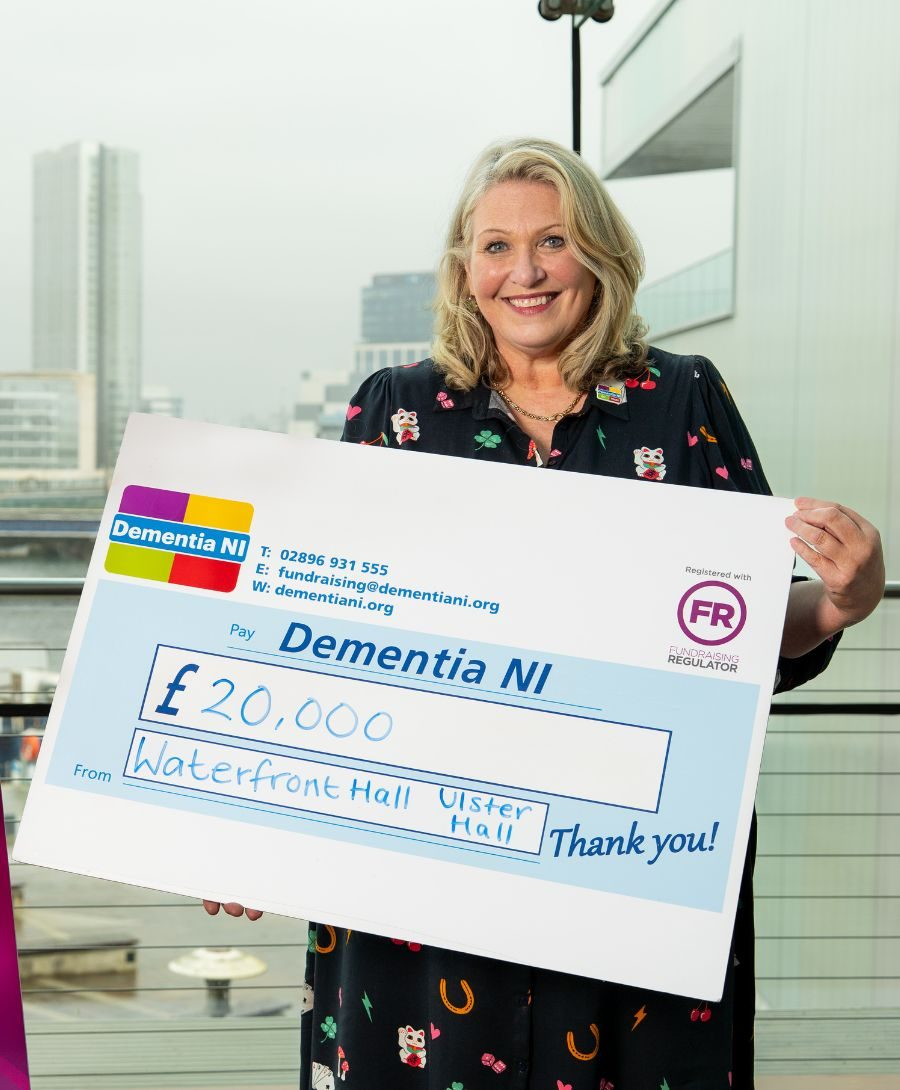 Man and woman smile for press shot holding cheque