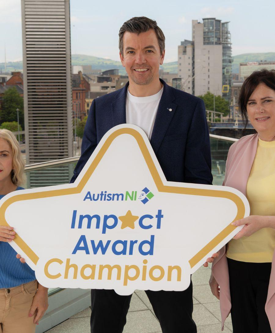 Two woman and one man stand on balcony for Autism Impact Award press shot
