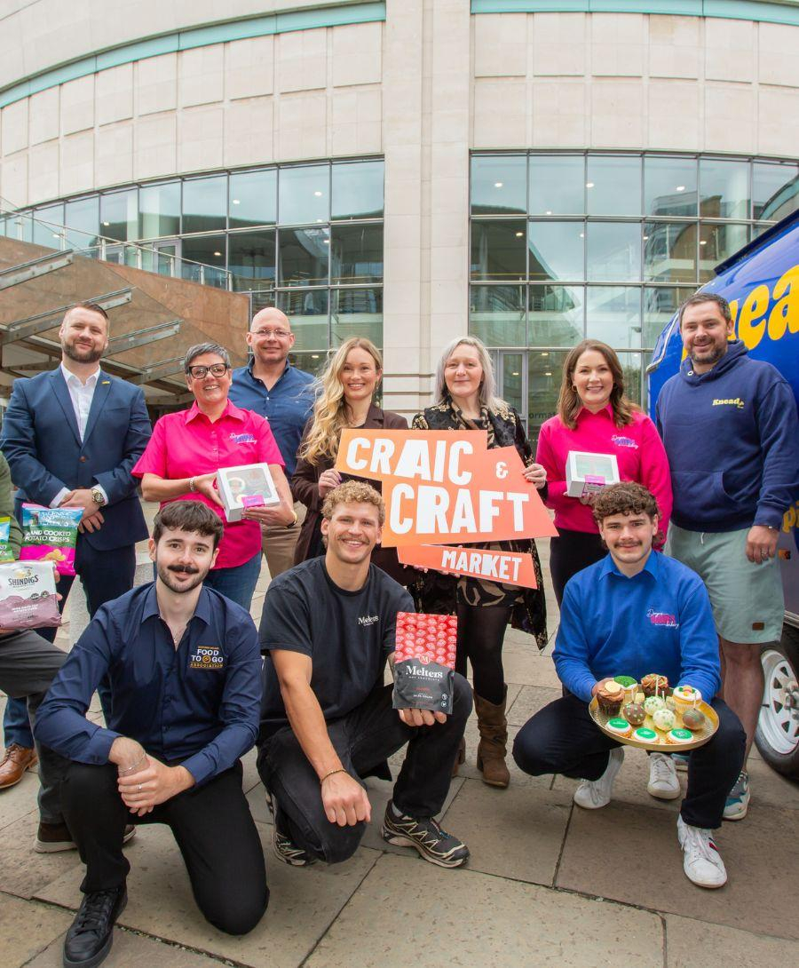 Group of people with food items smile for press shot outside ICC Belfast