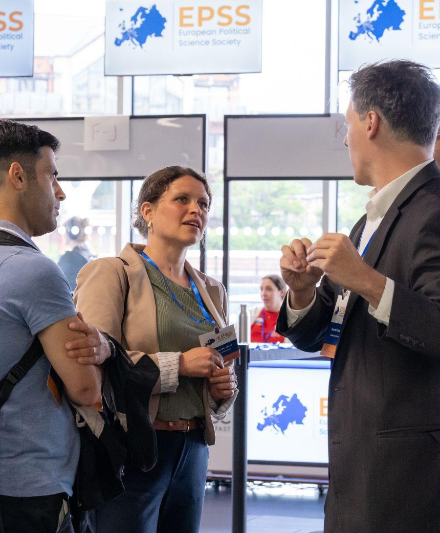 Image of one woman and three men in conversation at a conference