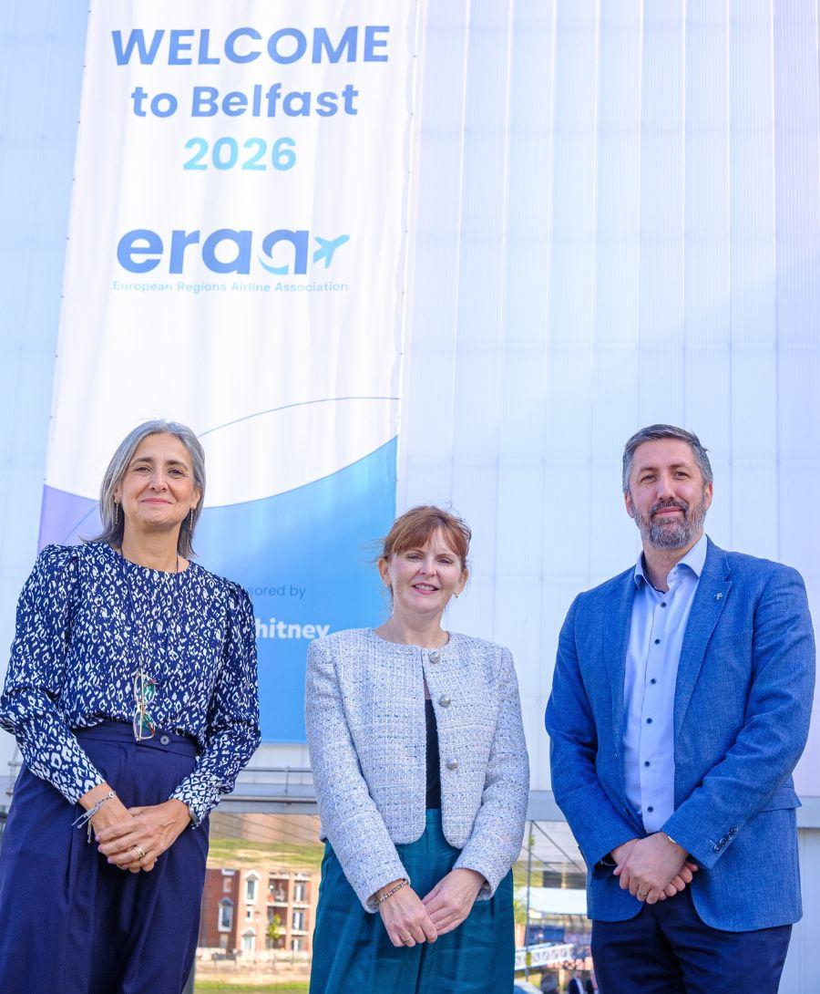 Minister and two Directors smile for press shot at conference