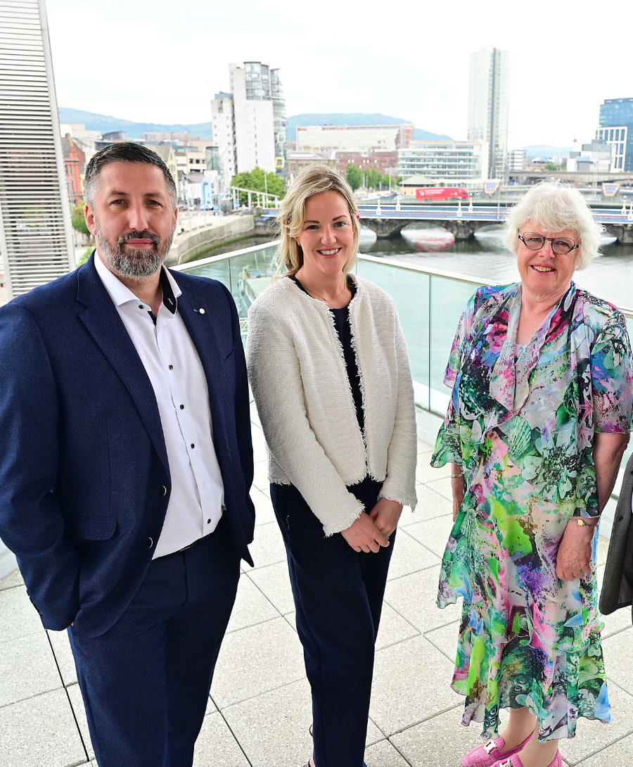 Image of two men and two women smiling on balcony for press shot