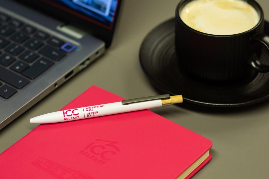Close up of ICC Belfast notebook, pen and cup of coffee on Boardroom table