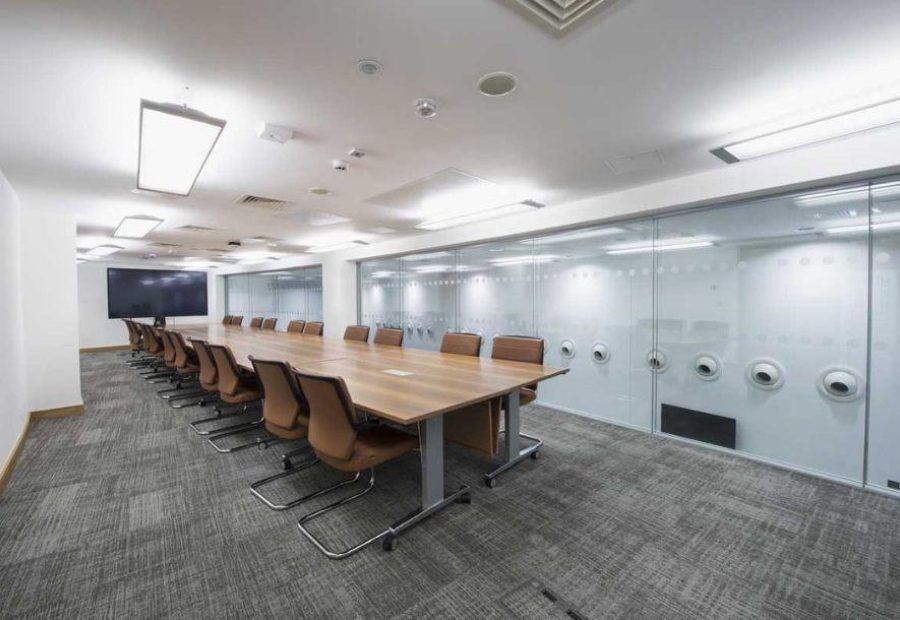 This image shows Boardroom 1 set up in boardroom style with a large TV screen at the far end of the table. This room as large windows which overlook Level 1 Foyer.