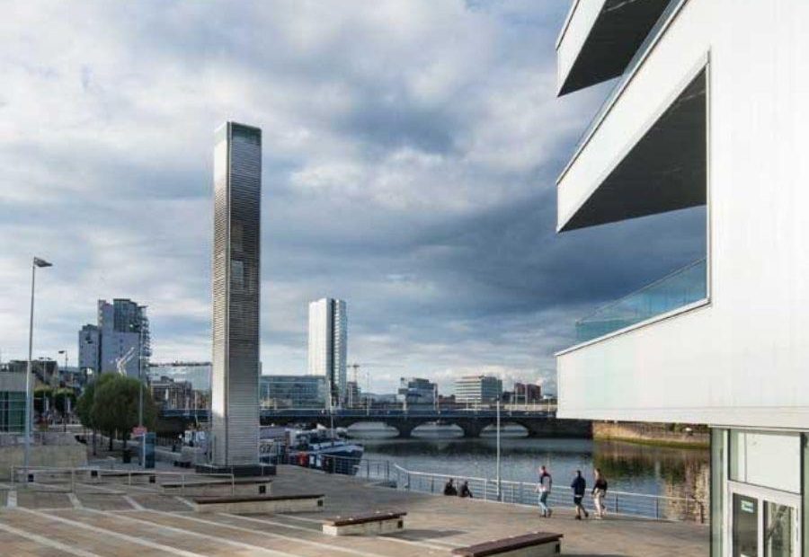 Image shows steps leading down to Riverside Entrance at ICC Belfast with balconies and Belfast cityscape in view.