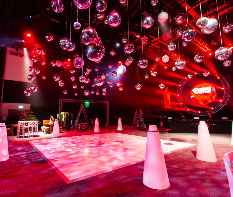 Hall 1 set up with a dance floor, strobe lights, branding and pine trees for the Coca Cola Evolve Conference 2024