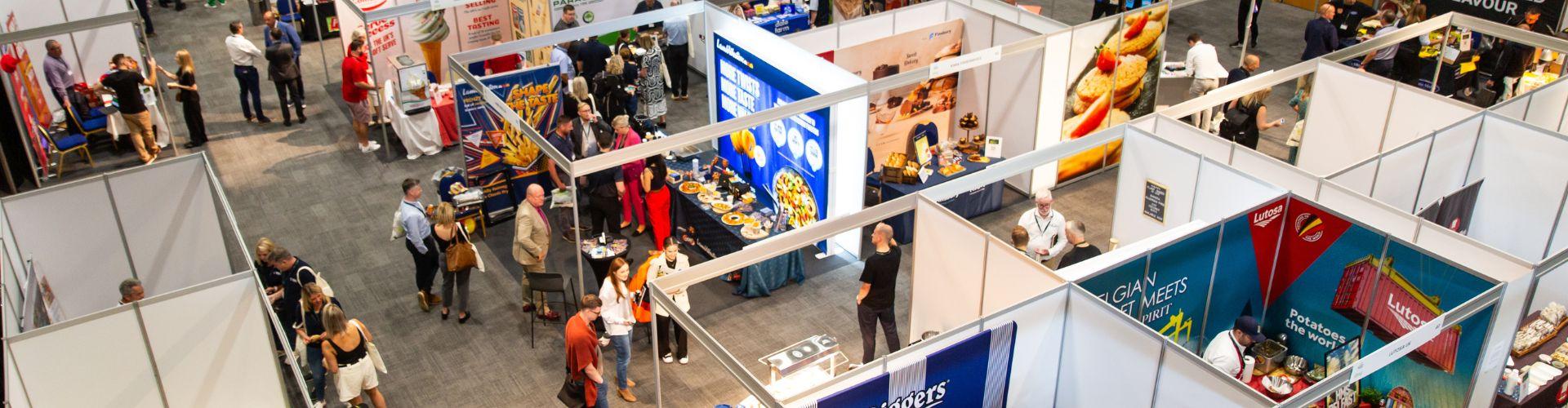 Birdseye view captured of a food exhibition set up filled with colour and people exploring the stalls